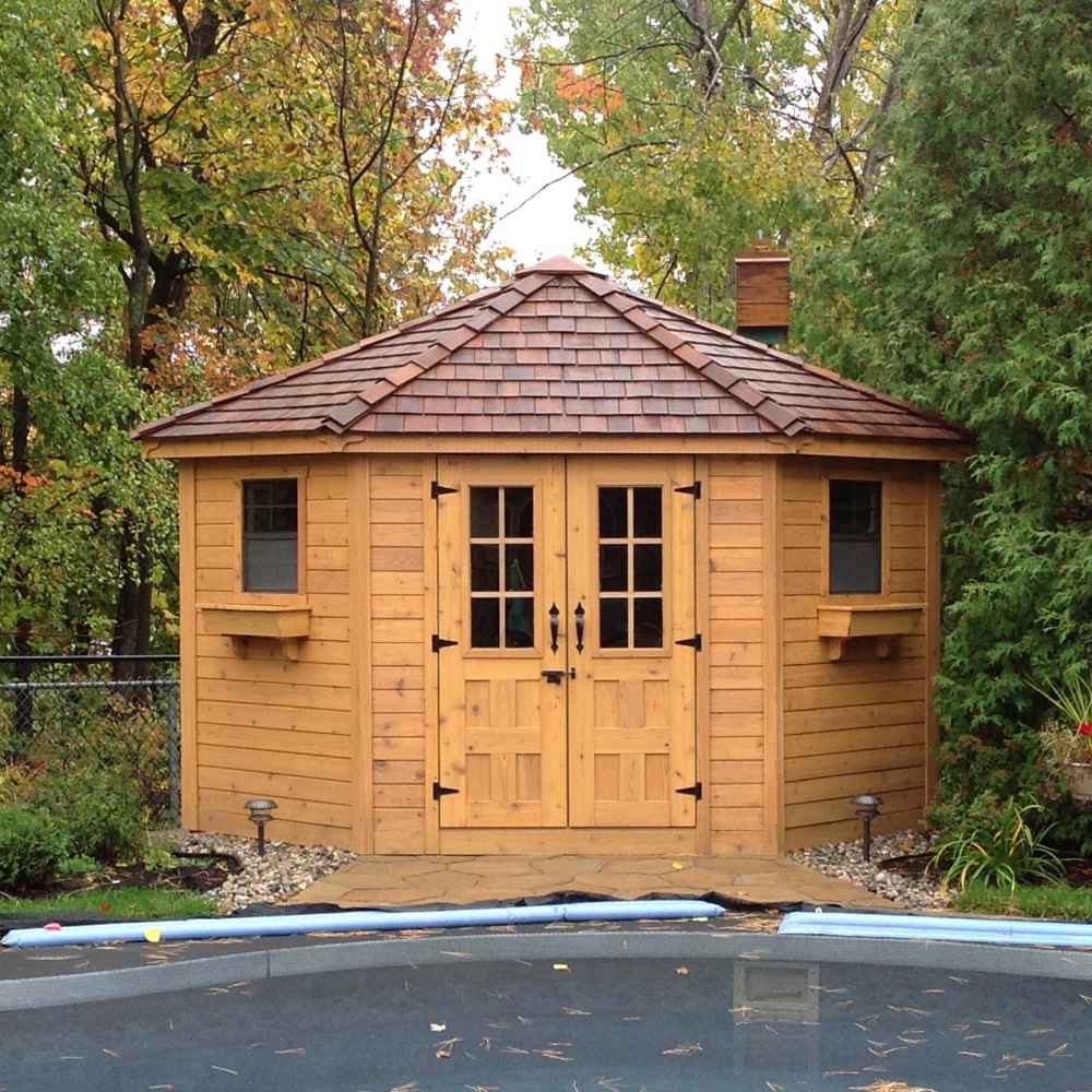 Outdoor Living Today 9×9 Penthouse Garden Shed stands proudly beside a pool, surrounded by autumn trees and garden plants