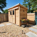Outdoor Living Today GardenSaver 12×4 with Sliding Doors sits beautifully in a gravel backyard surrounded by flowers and a wooden fence