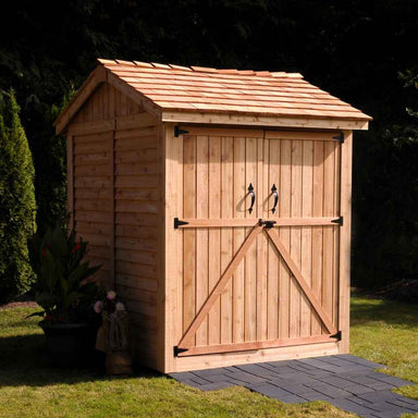 Outdoor Living Today Maximizer 6×6 Wooden Shed is pictured from the front corner, showing its solid wood construction and neatly finished shingle roof