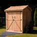 Outdoor Living Today Maximizer 6×6 Wooden Shed stands closed with double doors secured by black hinges and a lock, sitting on a paved walkway