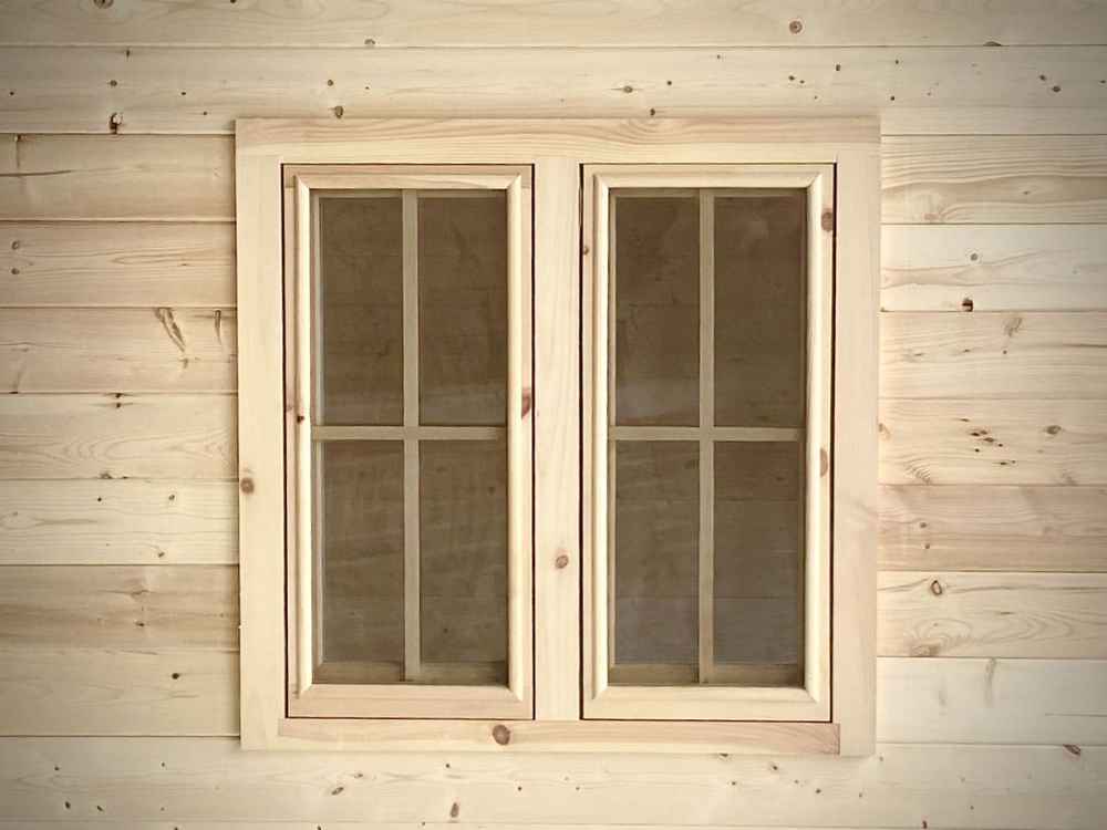 Pair of rectangular wooden windows with grid-pane glass panels on the exterior of the Sawmill Structures Harvest Grand Bungalow 107 Garden Room