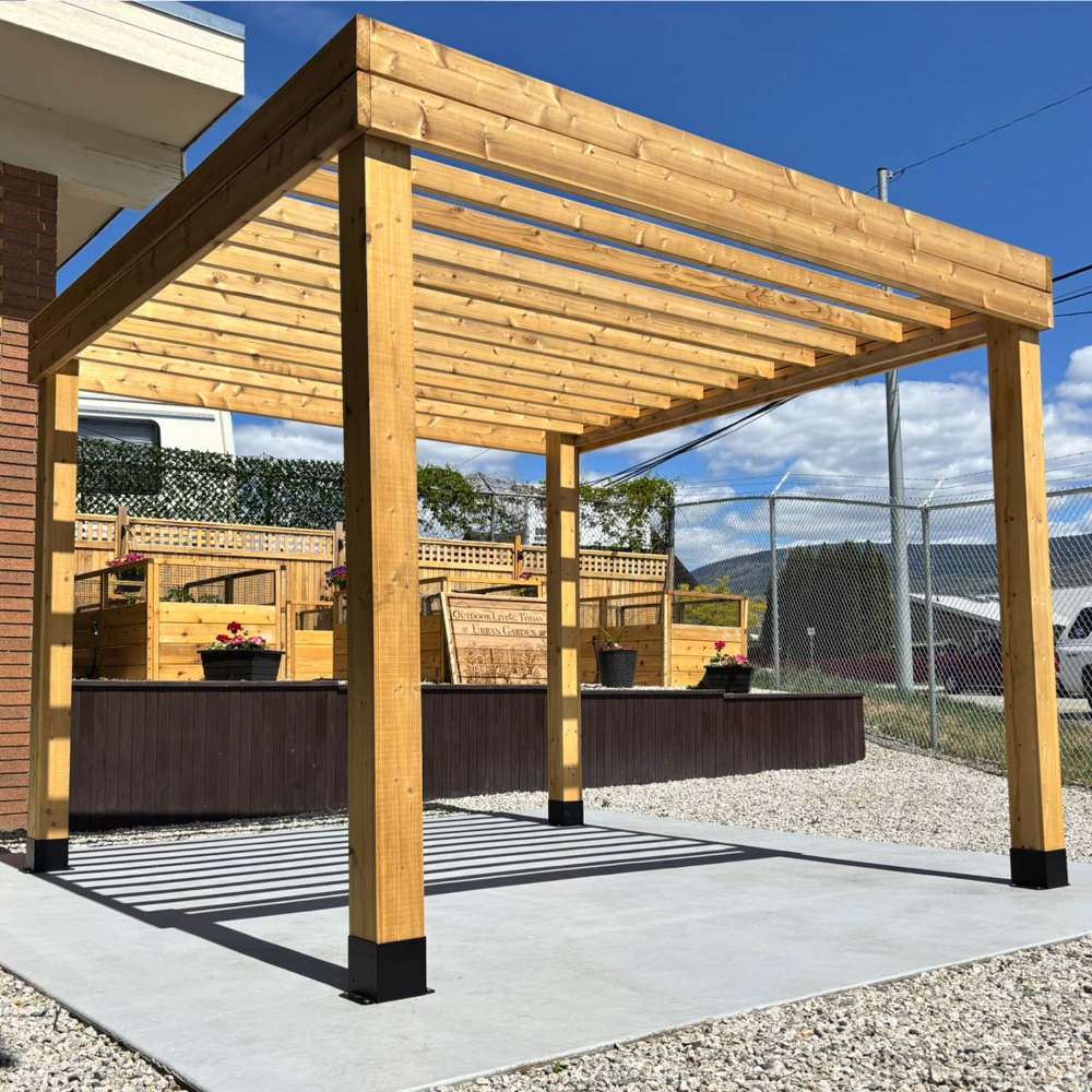 Pergola installed over a patio near a building featuring the Outdoor Living Today Western Red Cedar Urban Escape Pergola