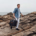 Person carries Jackery Upgraded Carrying Case Bag (L) over rocky ground for easy outdoor transport