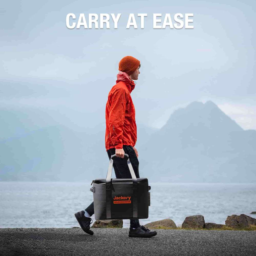 Person carries the Jackery Upgraded Carrying Case Bag (M) by its handles along a waterfront, highlighting its easy portability