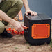 Person plugs Jackery Solar Panel Connector into a Jackery portable power station outdoors
