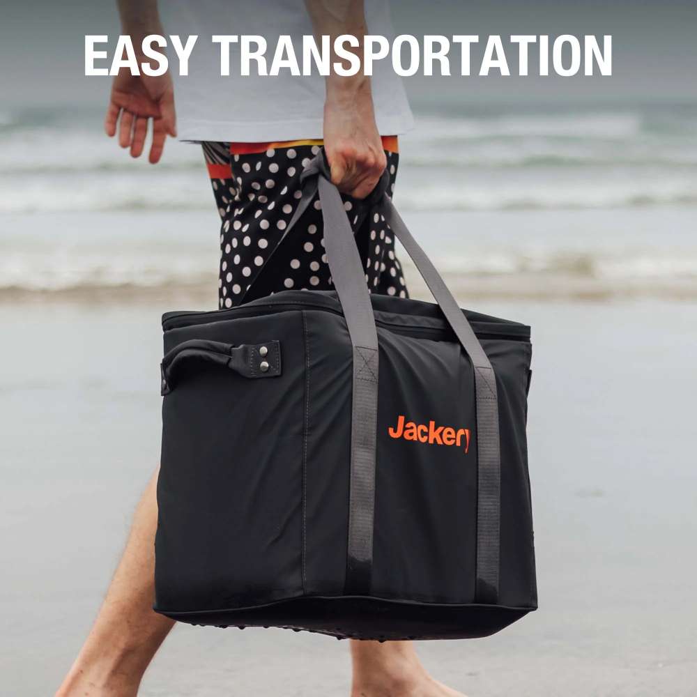 Person walks along the beach carrying Jackery Upgraded Carrying Case Bag (L) with its comfortable carry handles