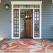 Placed at a front entrance, Couristan Monaco Indoor/Outdoor Rug - Coastal Flora/Ivory-Orange enhances curb appeal with its lively coastal palm leaf design