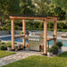 Poolside scene features Outdoor Living Today Western Red Cedar 8x5 Grill Gazebo covering a grill with string lights and plants