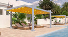 Poolside loungers rest under the bold yellow canopy of a Structureworks Balance Trex Pergola