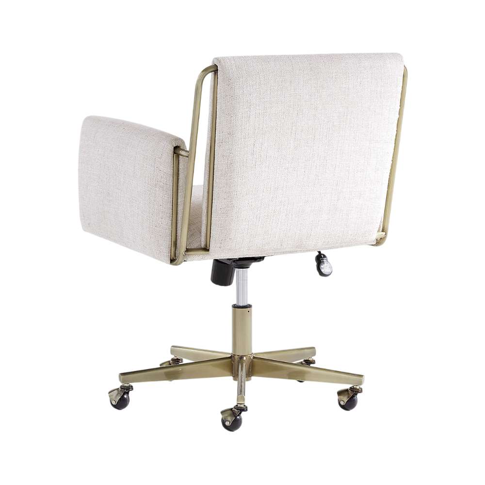 Rear view of Crate & Barrel Caterina Natural Upholstered Office Chair with Brass Base, showing its cream fabric upholstery, brass frame accents, and rolling caster base