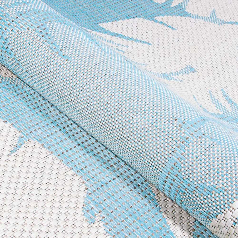 Rolled edge display emphasizes the flexible weave of Couristan Monaco Indoor/Outdoor Rug - Coastal Flora/Ivory-Turquoise