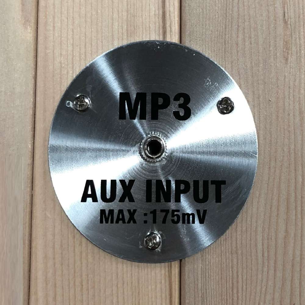 Round stainless MP3 AUX input plate mounted on the wood wall of Golden Designs Dynamic Avila Elite 1-2 Person Ultra Low EMF Far Infrared Sauna