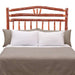 Rustic wooden bed with log-style rails and Fireside Lodge Hickory Log Wagon Wheel Headboard sits behind neatly arranged white and gray bedding