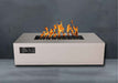 Sand Pebble Warming Trends AON Steel Rectangular Fire Pit Table burns warmly in an outdoor setting with a smooth, modern finish
