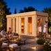Sauna Giusto 70 glowing with warm interior lighting at night while four adults enjoy a premium outdoor wellness experience.