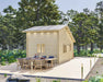 Sawmill Structures BlueWater Bungalow 160 Garden Room is shown with a large deck and elegant outdoor dining furniture under the trees