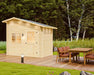 Sawmill Structures Bluewater Den 67 Garden Room angled to the side with a clear view of its door, windows, and wooden deck next to cushioned chairs