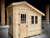 Sawmill Structures Bluewater Den 67 Garden Room from a slightly angled front view, highlighting its clean wooden exterior and framed windows