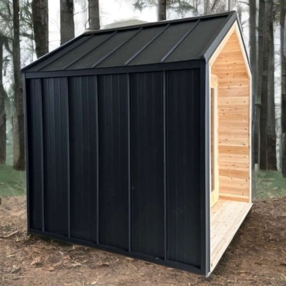 Sawmill Structures CabinSauna placed among forest trees, blending its black metal and wood exterior