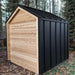 Sawmill Structures CabinSauna viewed from the side, showcasing its minimalist black metal roof and natural wood siding