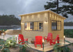 Sawmill Structures Eze Breeze Sunroom Cabin lit up at dusk surrounded by red Adirondack chairs on a spacious wooden deck