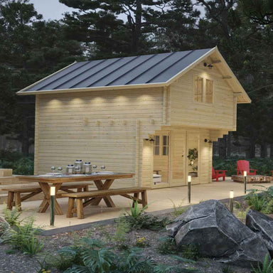 Sawmill Structures GrandView 150 70MM Garden Room is seen from the opposite side, featuring a rustic picnic table and soft lighting under the roof eaves