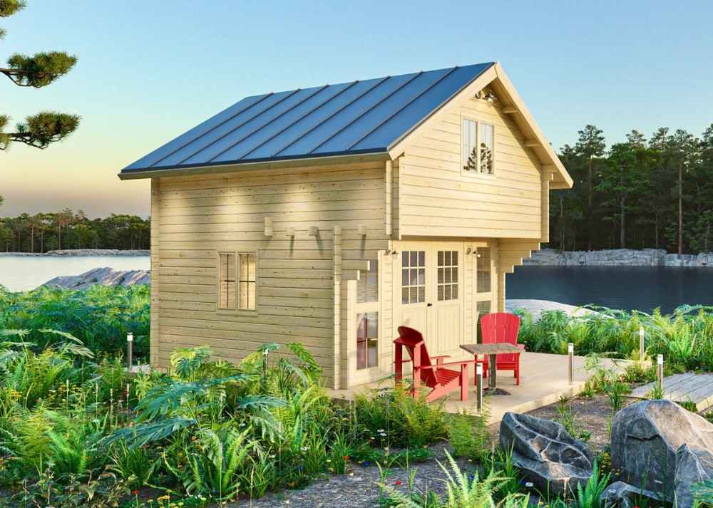 Sawmill Structures Grand Loft 107 Deluxe DD Garden Room is shown beside a calm lake, surrounded by greenery and rocks, with its double-decker cabin style fully visible