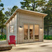 Sawmill Structures The Versa 107 70MM Garden Room sits sturdily on a wide platform, lit by soft wall sconces and complemented by a single red chair