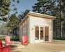 Sawmill Structures The Versa 107 70MM Garden Room stands peacefully on a spacious deck with vibrant red Adirondack chairs