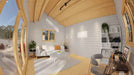Sawmill Structures The Versa 160 Atrium 70MM Garden Room interior highlights a homey setup with bookshelves, workspace, and a clean white rug
