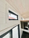 Sawmill Structures Wanderlove Tiny Home features slim black-framed windows near the ceiling
