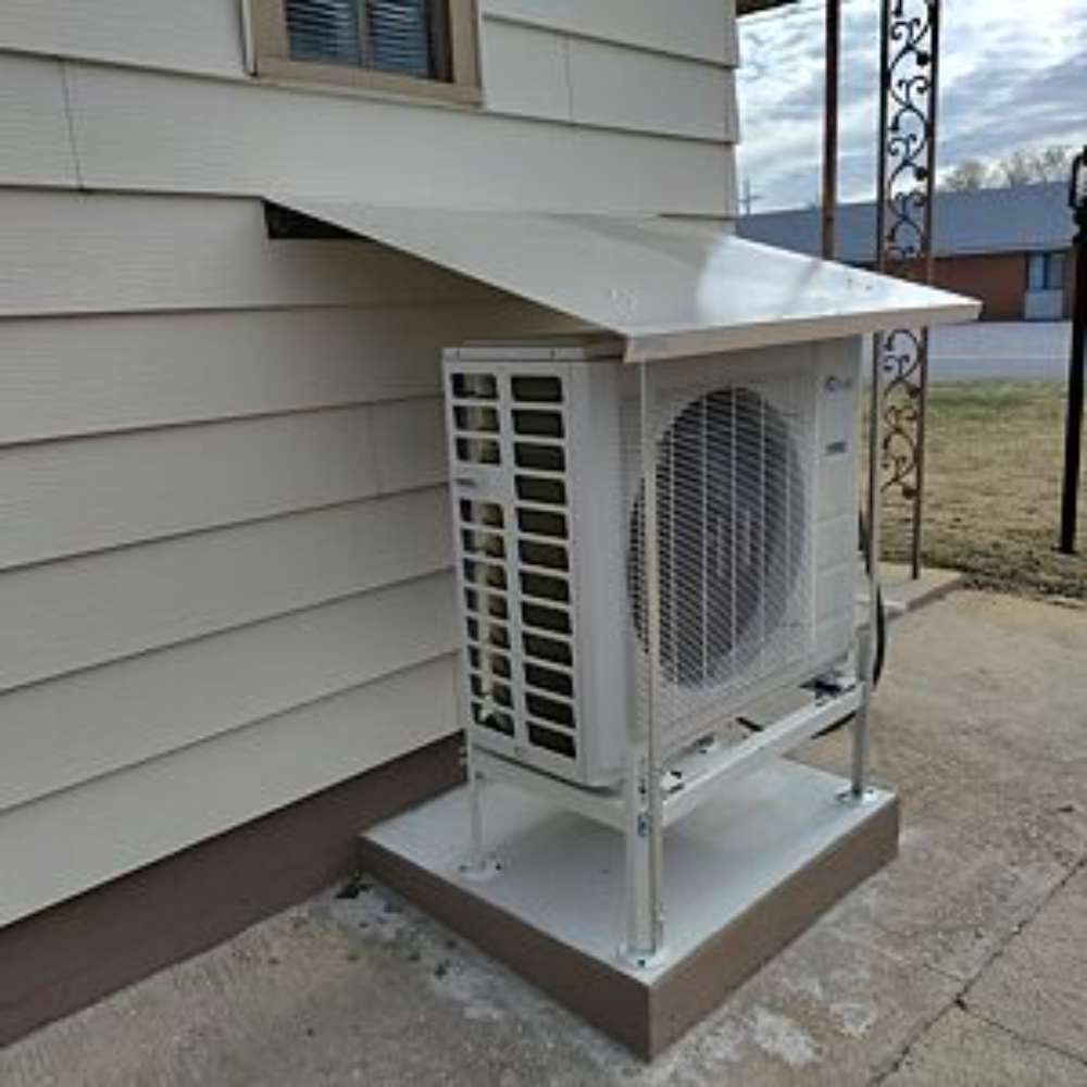Senville Large Outdoor Ground Stand/Bracket for Mini Split (18000-36000 BTU) installed beneath an overhang to keep the outdoor condenser elevated above the concrete pad