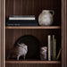 Shelf styling on Crate & Barrel Siena 34" Walnut Wood 4-Shelf Storage Bookcase with Drawer featuring books pottery and decorative accents