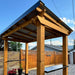 Side angle of Outdoor Living Today Western Red Cedar 8x5 Grill Gazebo shows its strong posts, sloped roof, and built-in side shelves