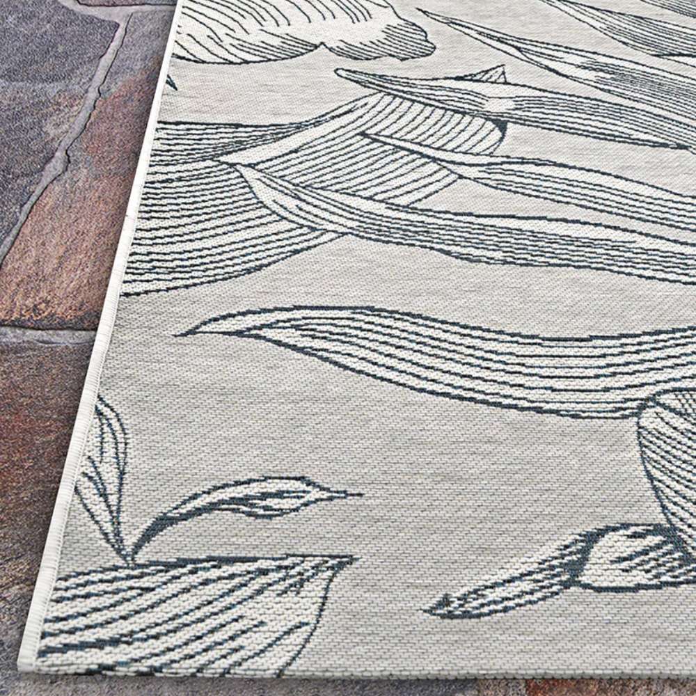 Side-angle view of Couristan Dolce Indoor/Outdoor Rug - Flora/Argento highlights its thin profile and crisp floral patterns along the edge