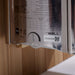 Side label on the stainless Harvia stove of Golden Designs Sundsvall 2 Person Traditional Sauna showing a printed spec chart, a timer dial and The Wall logo