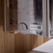 Side label on the stainless stove of Golden Designs Osla 6 Person Traditional Sauna showing a printed spec chart, a timer dial and The Wall logo