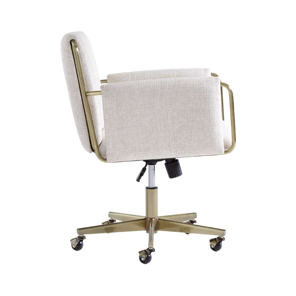 Side profile of Crate & Barrel Caterina Natural Upholstered Office Chair with Brass Base, showing its upholstered armrests, brass frame, and adjustable swivel base