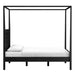 Side profile of Crate & Barrel Keane Black Solid Wood Queen Canopy Bed showing the tall canopy frame and sleek, modern silhouette
