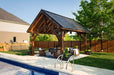 Side view of Brookside Timber Frame Alpine Lodge Pavilion highlights its sturdy wooden beams and luxurious outdoor furniture