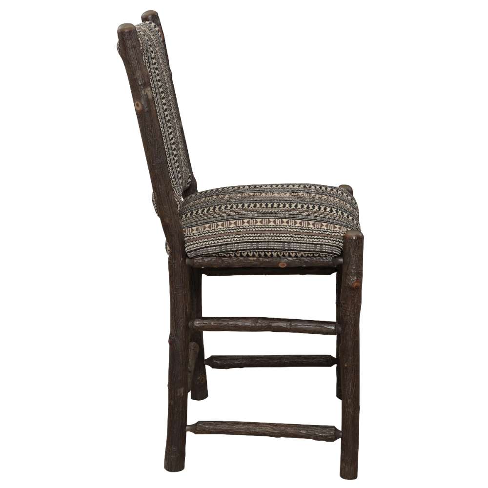 Side view of Fireside Lodge Hickory Log Upholstered Counter Stool highlights its solid hickory log frame, reinforced stretchers, and thick padded upholstery