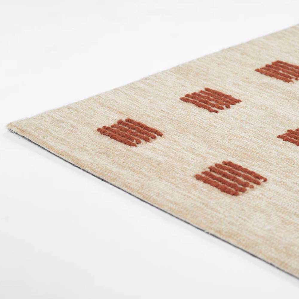 Side angle showing the slim and flat design of Momeni Archer Indoor Rug - ARC-1 Rust with rust-colored squares on a beige background
