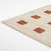 Side angle showing the slim and flat design of Momeni Archer Indoor Rug - ARC-1 Rust with rust-colored squares on a beige background