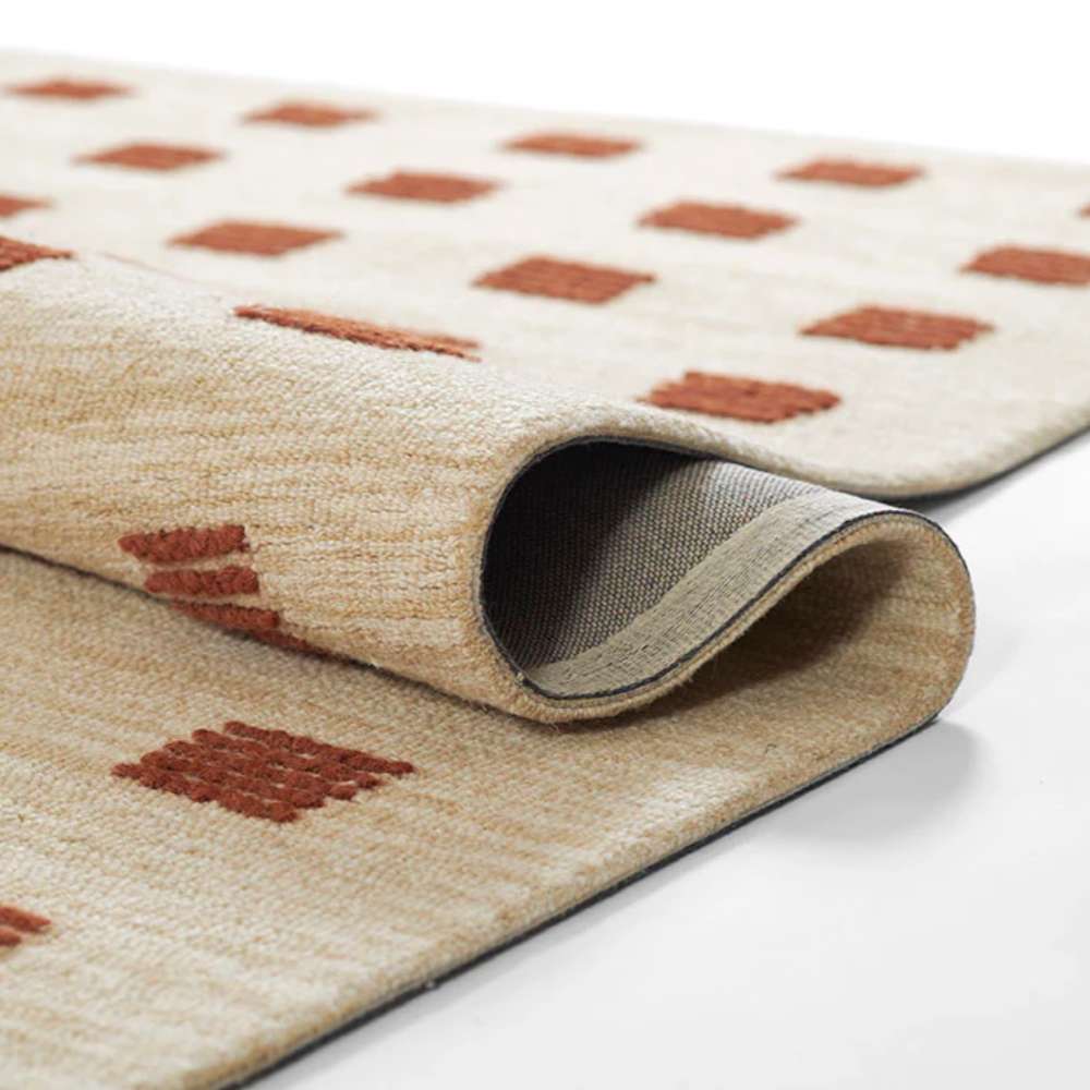 Side fold of Momeni Archer Indoor Rug - ARC-1 Rust showing its thin profile and woven backing