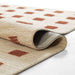 Side fold of Momeni Archer Indoor Rug - ARC-1 Rust showing its thin profile and woven backing