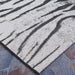 Side view of Couristan Dolce Indoor/Outdoor Rug - Bengal/Ivory lying flat on stone tiles
