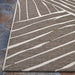 Side view of Couristan Dolce Indoor/Outdoor Rug - Parquet/Mocha reveals its smooth weave and sharp diagonal lines across a mocha base