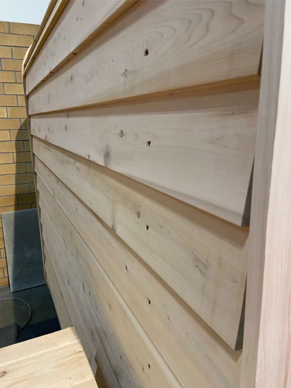 Side view of Sawmill Structures Box Sauna showing its sleek overlapping wood panels for a weather-resistant finish