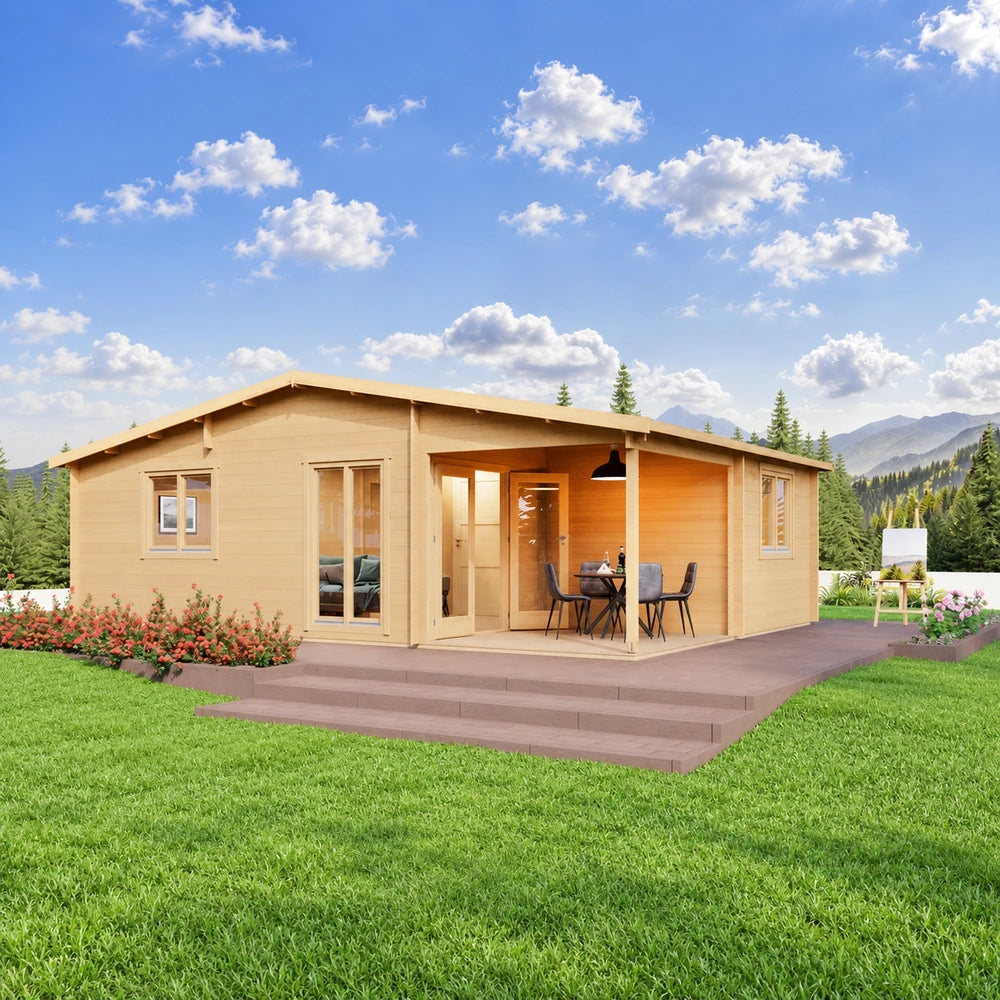 Skanderborg 44 wooden garden room with a covered dining porch, glazed doors and wraparound deck, surrounded by colorful landscaping with evergreen trees and mountains beyond.