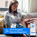 Smiling woman holding a phone with the Smart Life app shows remote Wi-Fi operation of the ACiQ 24000 BTU Essentials 23 SEER2 2 Zone Wall Mount Mini Split Heat Pump System